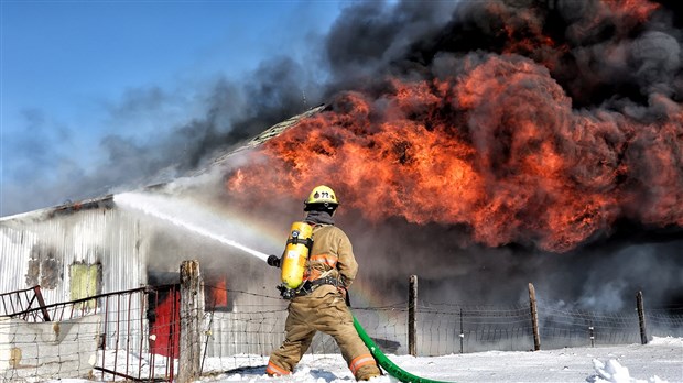 Un bâtiment de ferme en proie aux flammes