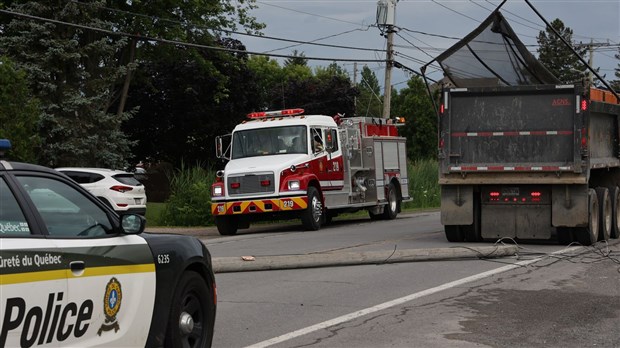 Un camion benne arrache un poteau électrique et des fils sur la route 201 